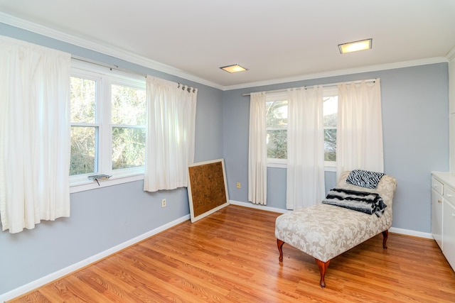 sitting room with crown molding, a wealth of natural light, and light hardwood / wood-style floors