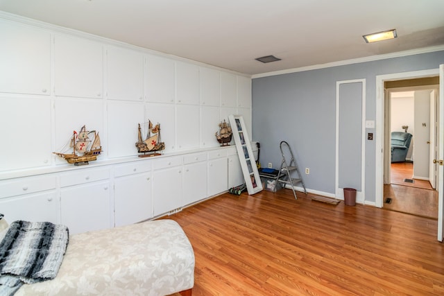 sitting room with crown molding and light hardwood / wood-style flooring