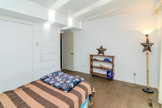 bedroom featuring ornamental molding and dark hardwood / wood-style flooring