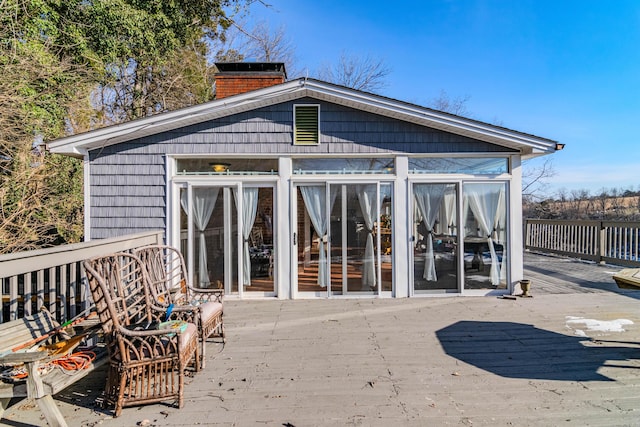 exterior space featuring a wooden deck and a sunroom