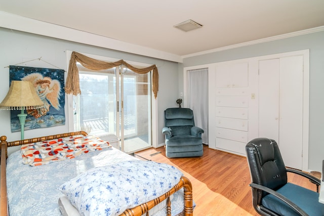 bedroom featuring ornamental molding, hardwood / wood-style floors, and access to exterior