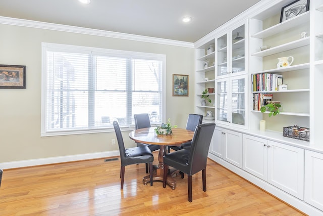 dining room with light hardwood / wood-style flooring and ornamental molding