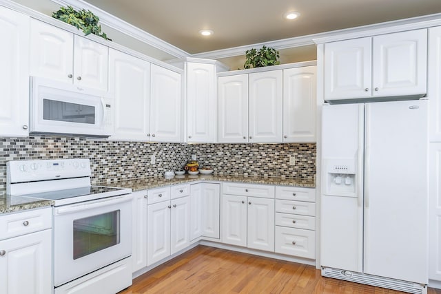 kitchen featuring white cabinetry, decorative backsplash, light stone counters, crown molding, and white appliances