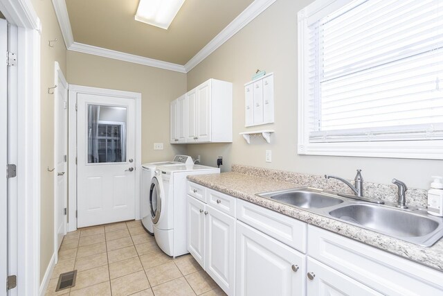 clothes washing area with light tile patterned floors, sink, crown molding, cabinets, and washing machine and clothes dryer