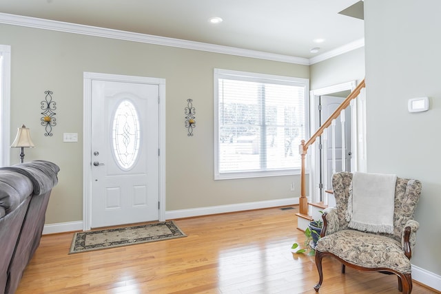 foyer entrance featuring ornamental molding and light hardwood / wood-style flooring