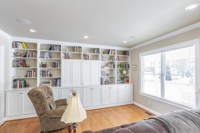 living area with ornamental molding and light wood-type flooring