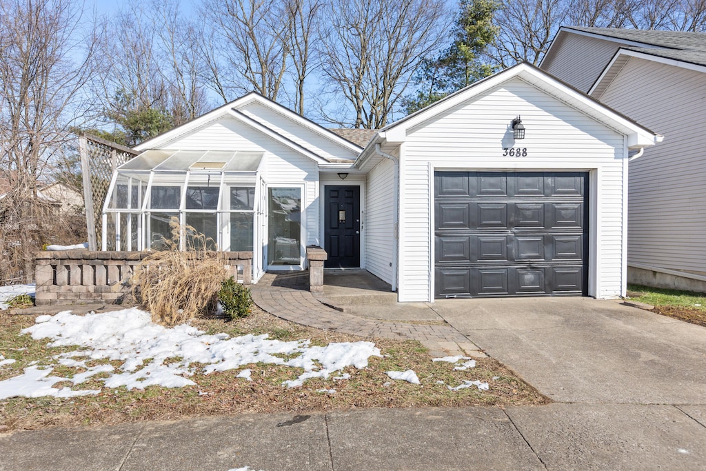 ranch-style home with a garage and a sunroom