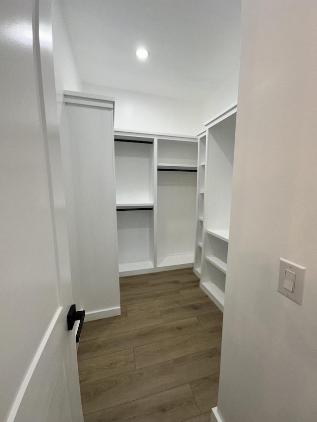 spacious closet with dark hardwood / wood-style flooring