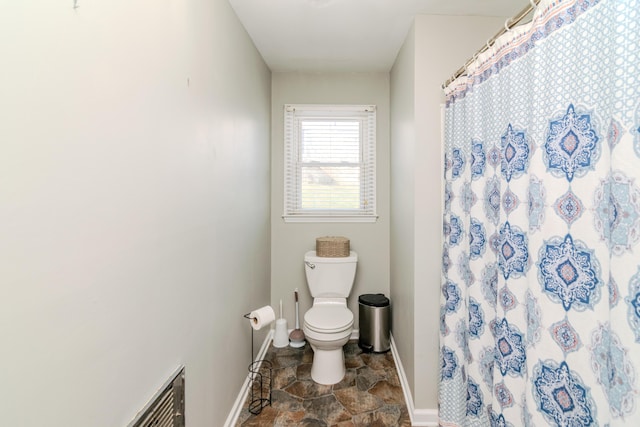 bathroom featuring toilet and a shower with shower curtain