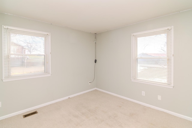 unfurnished room featuring light colored carpet