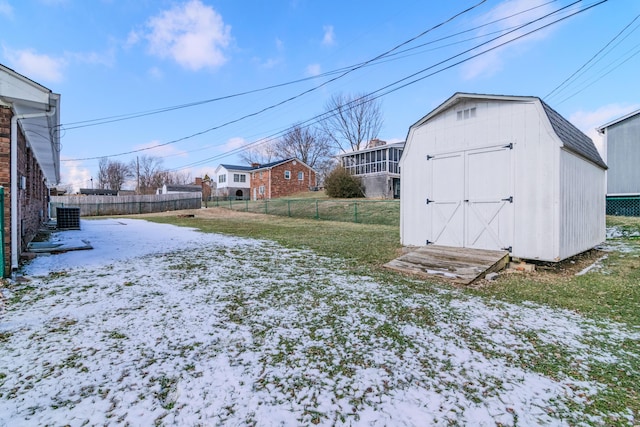 yard covered in snow featuring a storage shed