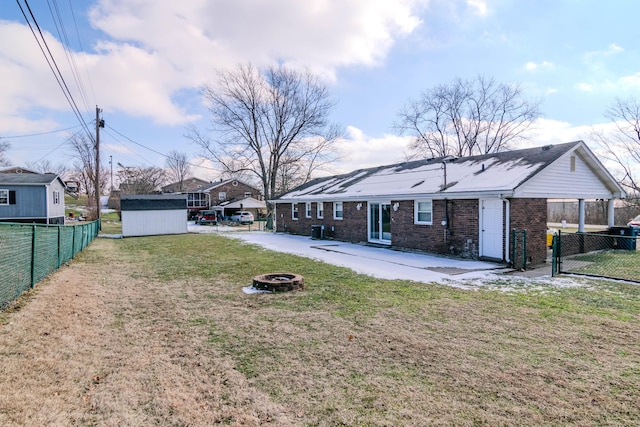 view of yard with a storage shed, an outdoor fire pit, and a patio area