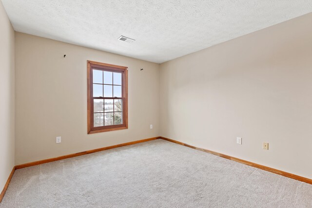 carpeted spare room with a textured ceiling