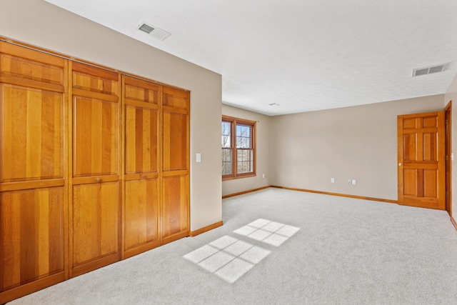 unfurnished bedroom featuring baseboards, visible vents, and carpet flooring