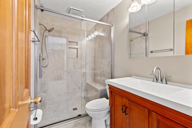 bathroom with a textured ceiling, toilet, vanity, marble finish floor, and a stall shower