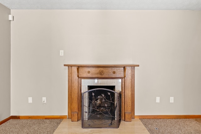 details with a textured ceiling, a fireplace with flush hearth, and baseboards