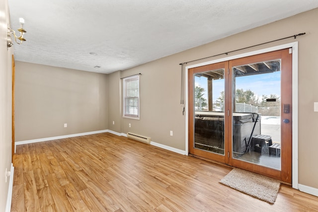 empty room with a baseboard radiator, a textured ceiling, and light wood-type flooring