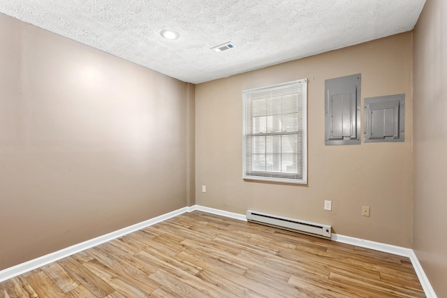 unfurnished room with a textured ceiling, a baseboard radiator, wood finished floors, baseboards, and electric panel