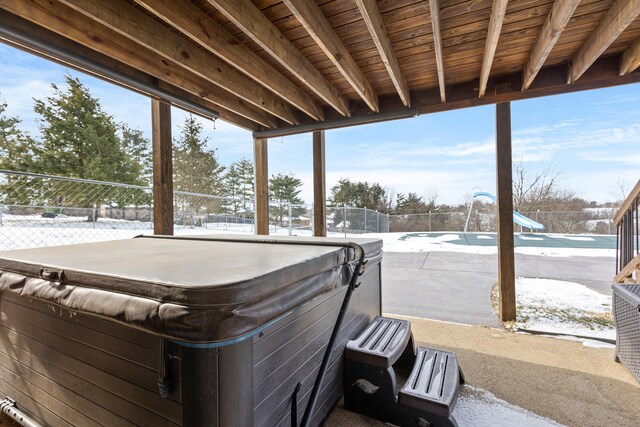 snow covered property featuring a hot tub and a sunroom