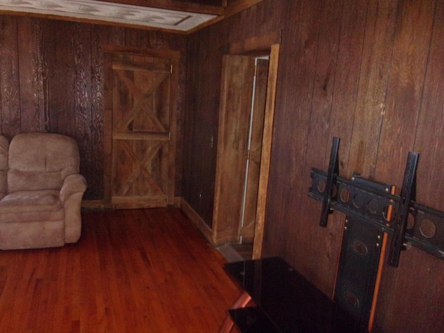 living area with dark hardwood / wood-style floors and wooden walls