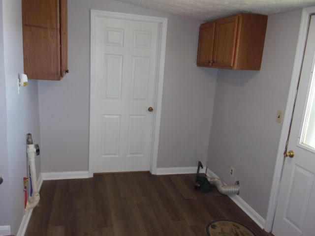 laundry room featuring dark wood-type flooring and a textured ceiling