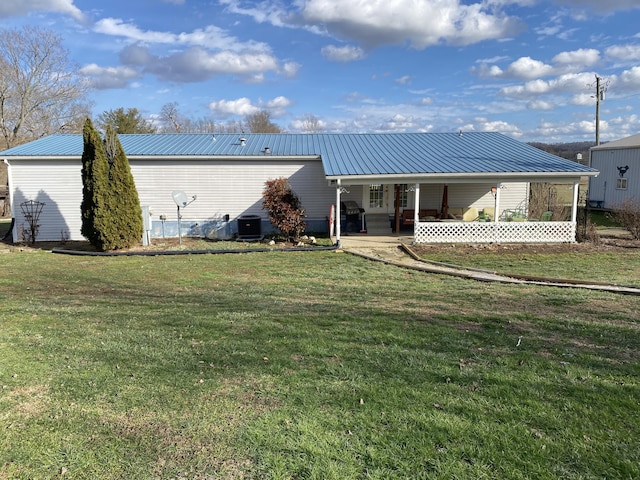 back of property with a yard and central AC