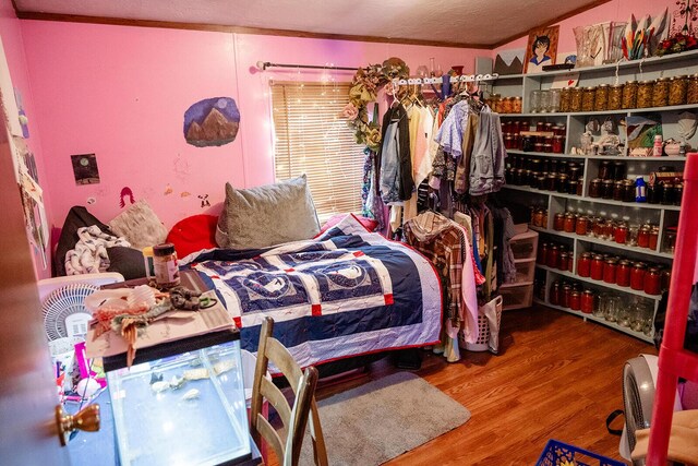 bedroom featuring hardwood / wood-style floors and crown molding