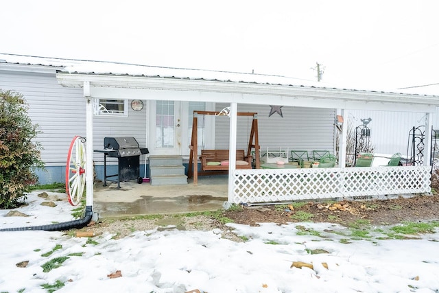 snow covered property featuring a porch