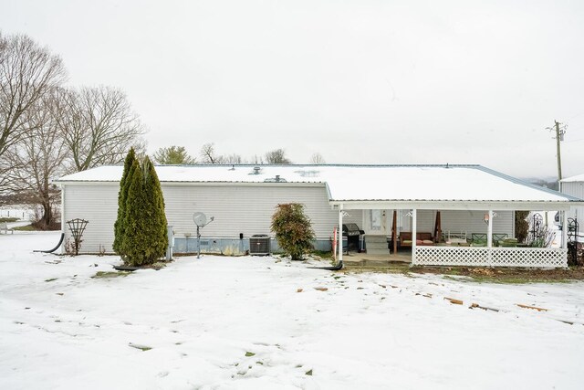 snow covered property featuring covered porch and cooling unit