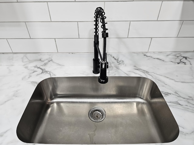 details featuring light stone countertops and a sink