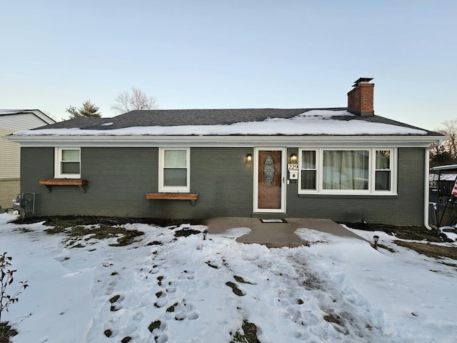 view of front of house with brick siding and a chimney