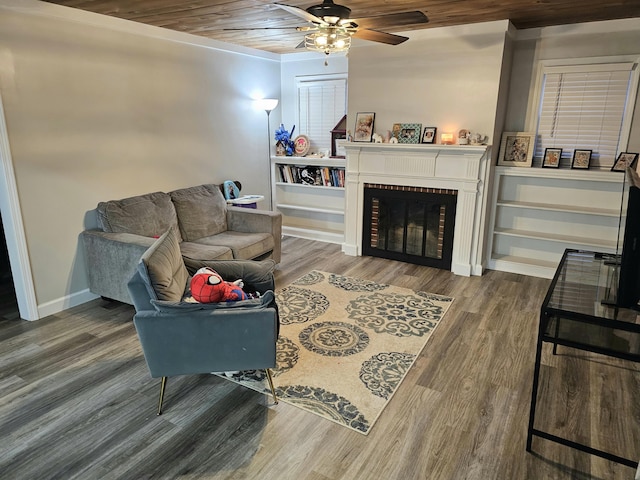 living area featuring baseboards, wooden ceiling, ceiling fan, wood finished floors, and a fireplace