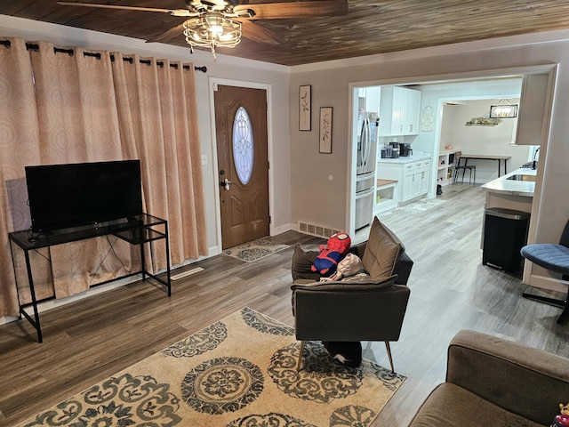 living area featuring wood ceiling, light wood-style flooring, visible vents, and baseboards