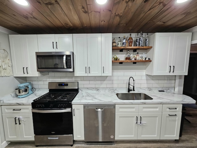 kitchen featuring stainless steel appliances, white cabinets, a sink, and decorative backsplash