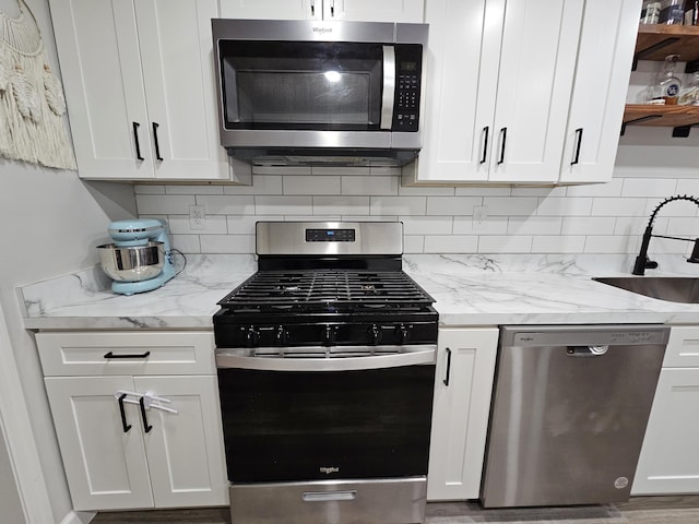 kitchen featuring stainless steel appliances, a sink, backsplash, and open shelves