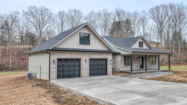 view of front of property with cooling unit, a garage, and covered porch