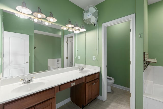 bathroom featuring a relaxing tiled tub, vanity, and toilet