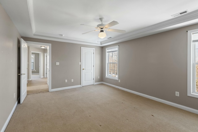 carpeted spare room featuring ceiling fan and a raised ceiling