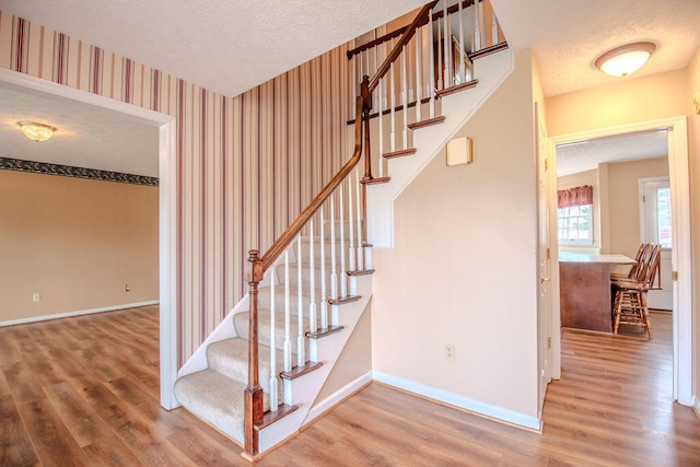 stairs featuring hardwood / wood-style floors and a textured ceiling