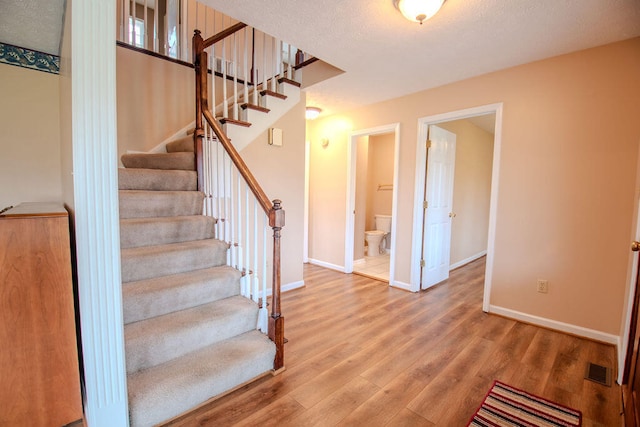 stairs featuring hardwood / wood-style flooring