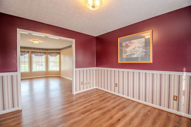 empty room featuring hardwood / wood-style flooring and a textured ceiling