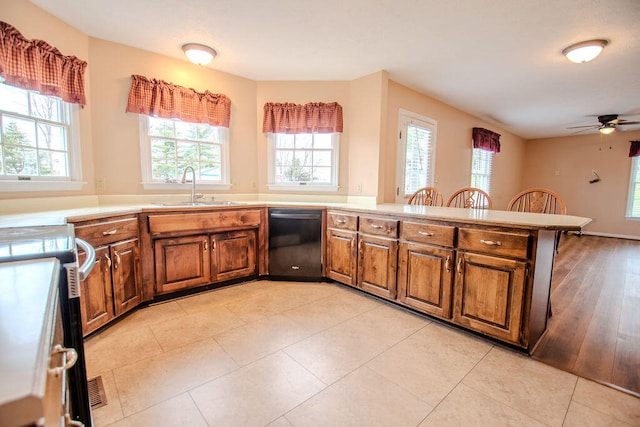 kitchen with dishwasher, sink, light tile patterned floors, and kitchen peninsula