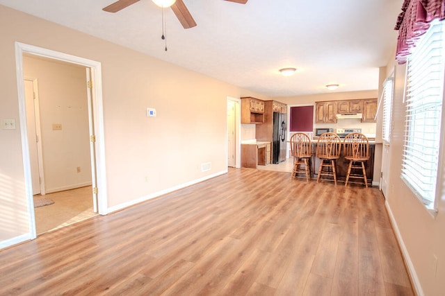 unfurnished living room featuring ceiling fan and light hardwood / wood-style floors