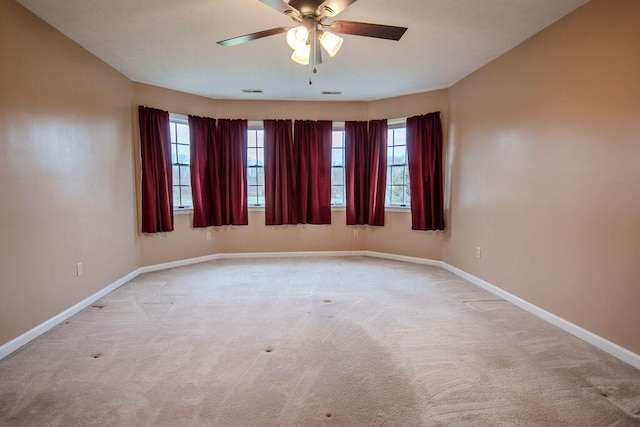 unfurnished room with light colored carpet and ceiling fan