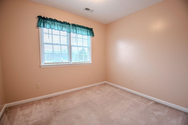 carpeted empty room with a textured ceiling