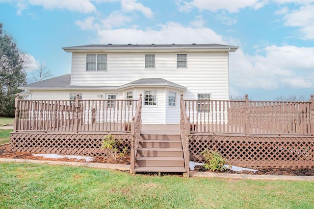 rear view of property featuring a deck and a lawn