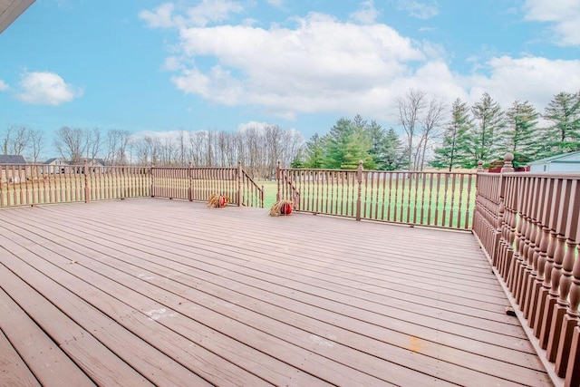 wooden terrace featuring a lawn