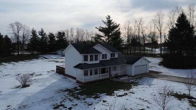 snow covered rear of property with a garage