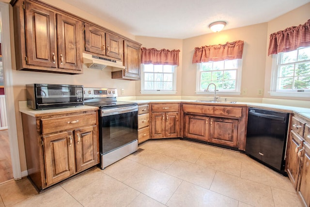 kitchen featuring sink, a wealth of natural light, light tile patterned floors, and black appliances