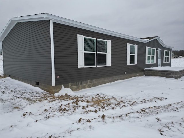 view of snow covered exterior with crawl space